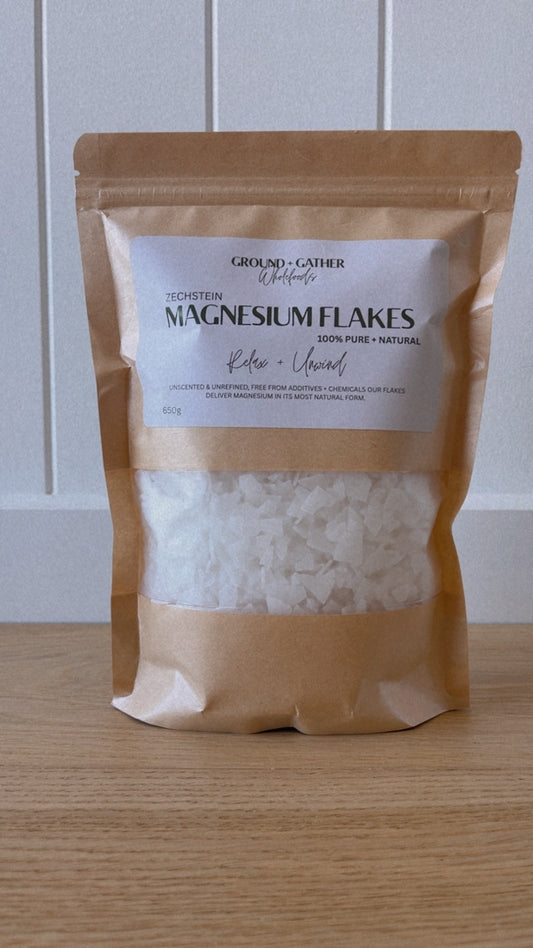 Bag of magnesium flakes on a wooden surface with a white background