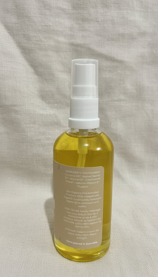 Clear spray bottle with yellow liquid on a linen surface