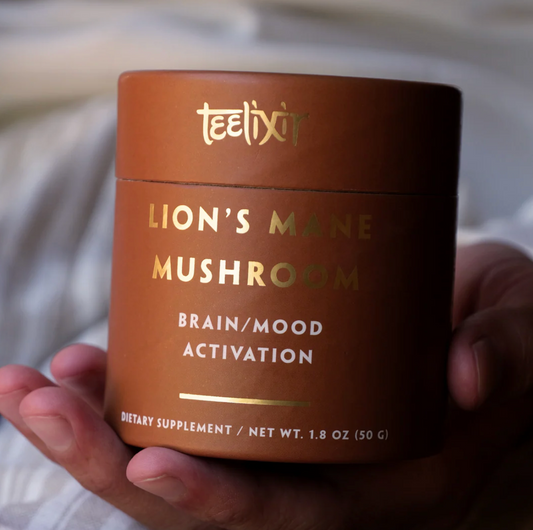 Teelixir Lion's Mane Mushroom supplement container held in a hand with a blurred background