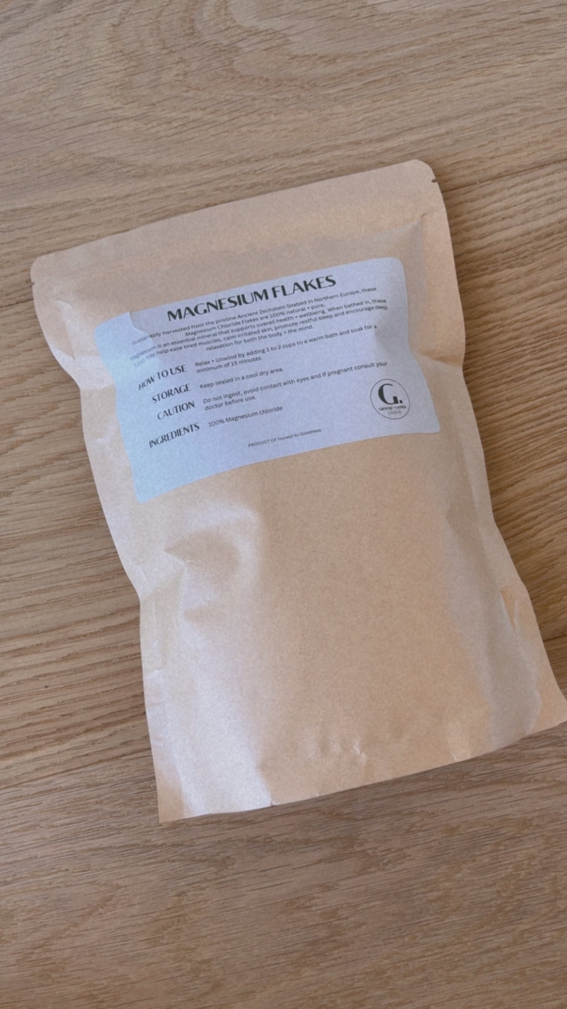 Beige package of magnesium flakes with a label on a wooden surface