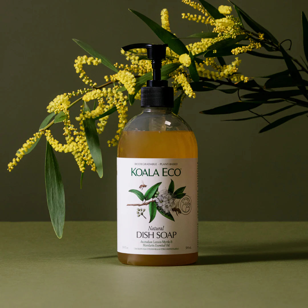 Koala Eco dish soap bottle with yellow flowers and green leaves on a green background